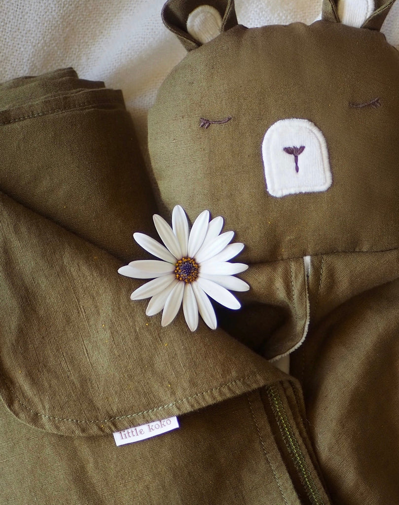 little koko bear comforter made with olive green linen and cotton, with a pretty flower