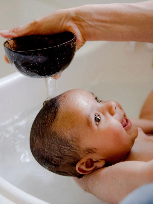 happy baby in the bath enjoying aqua massage with little koko bath time coconut shells