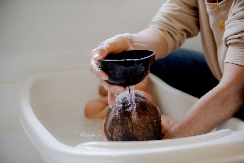 bath-time coconut shells and baby enjoying aqua massage with his mother
