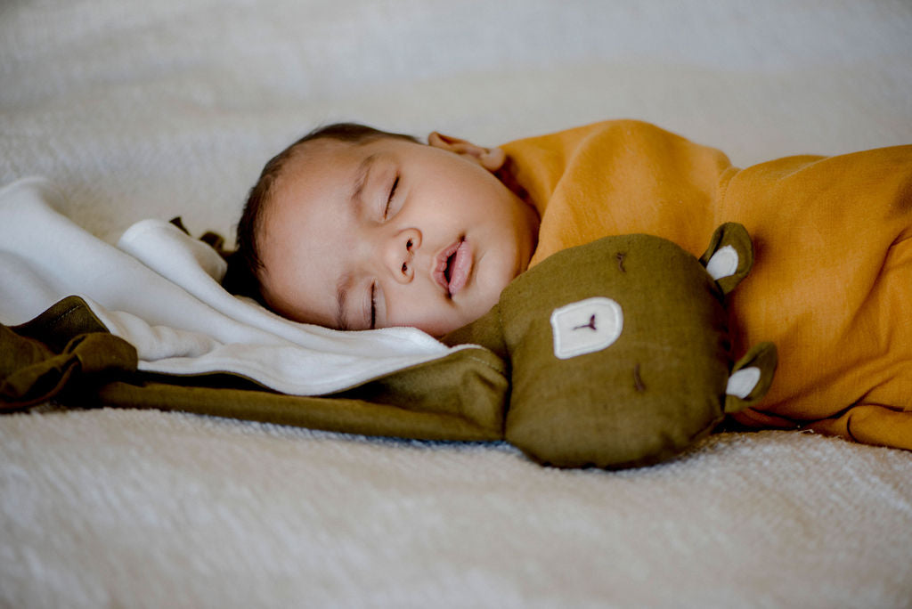 swaddled baby sleeping with little koko bear comforter 